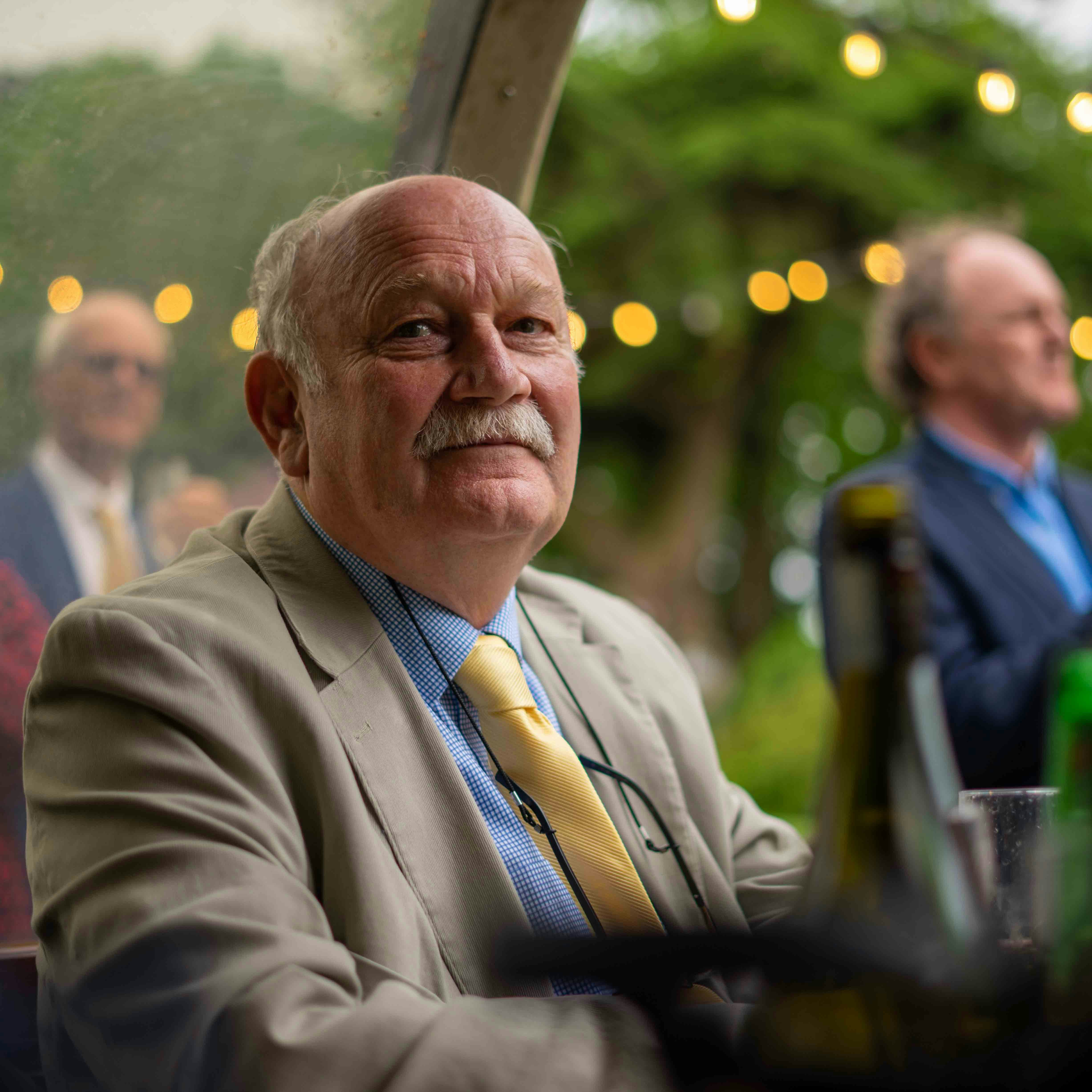 60-year-old man seated at a restaurant looking at camera