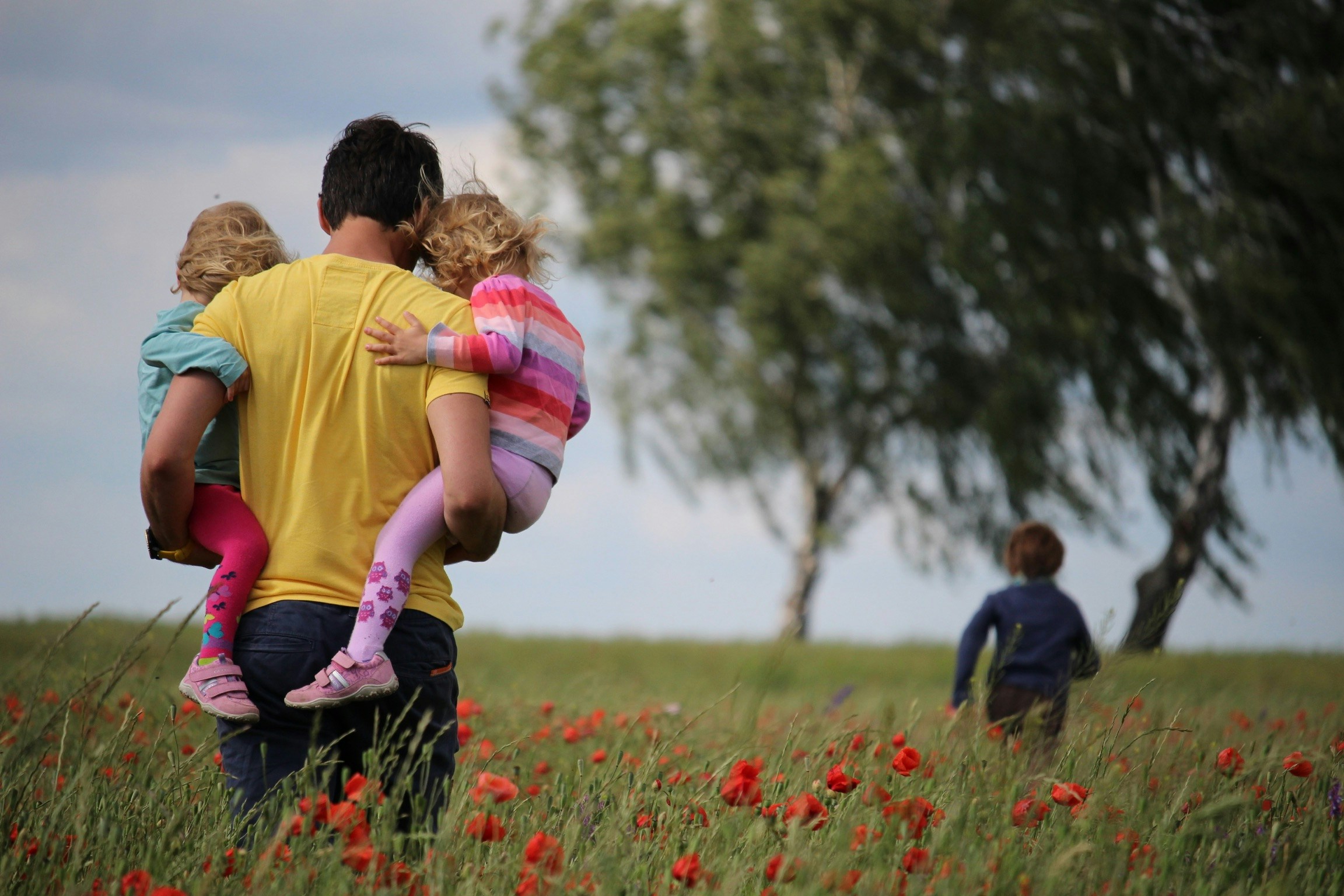 A father and his three children in a flower field