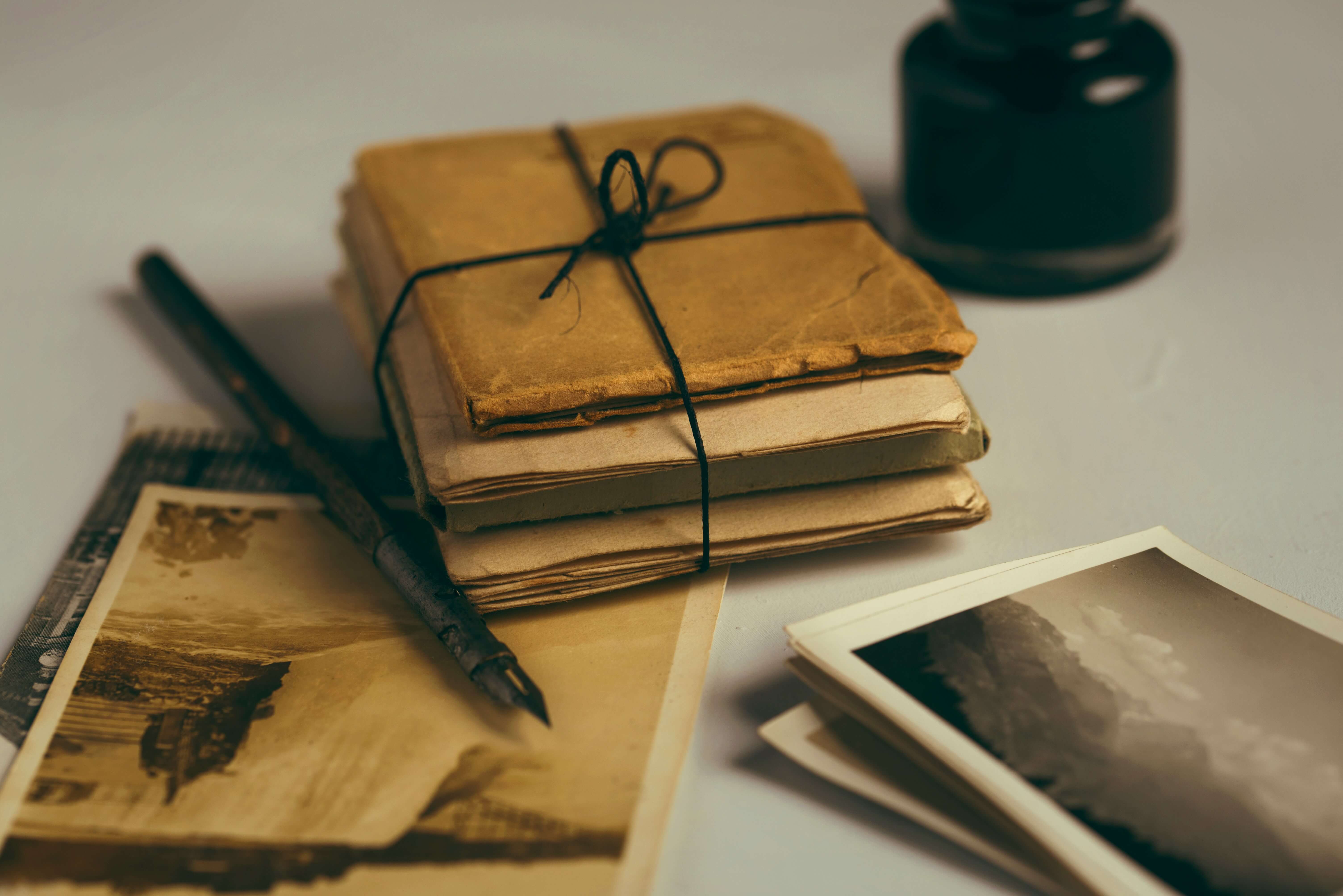 Bundle of brown envelopes and a black ink pen beside it