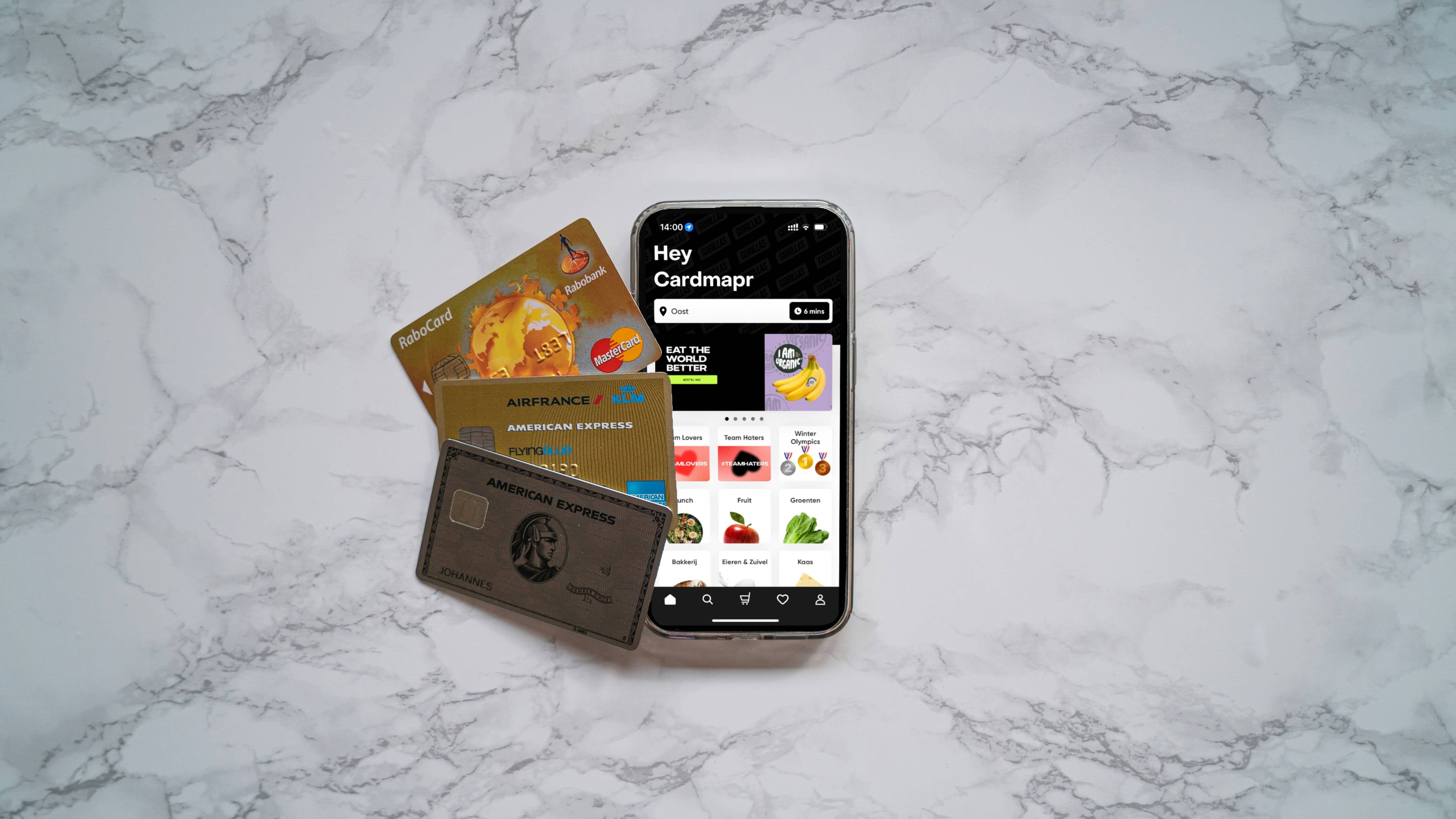 Credit cards placed next to smartphone with an open shopping website