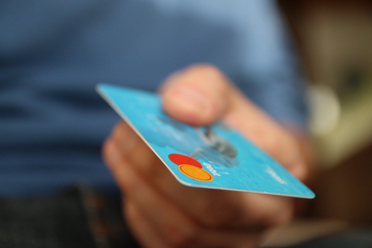  Hand presenting a credit card to the foreground