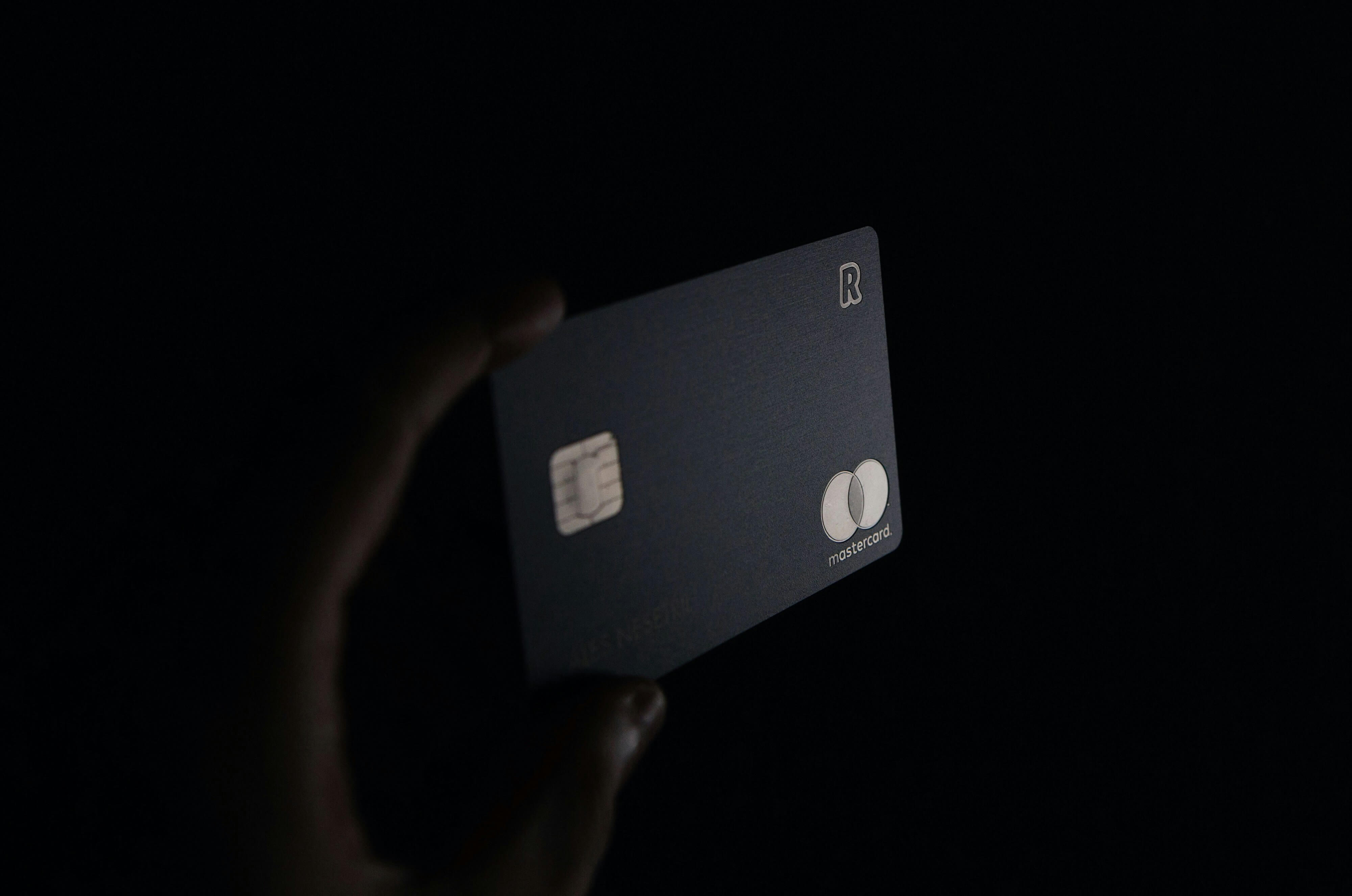 Person holding black credit card